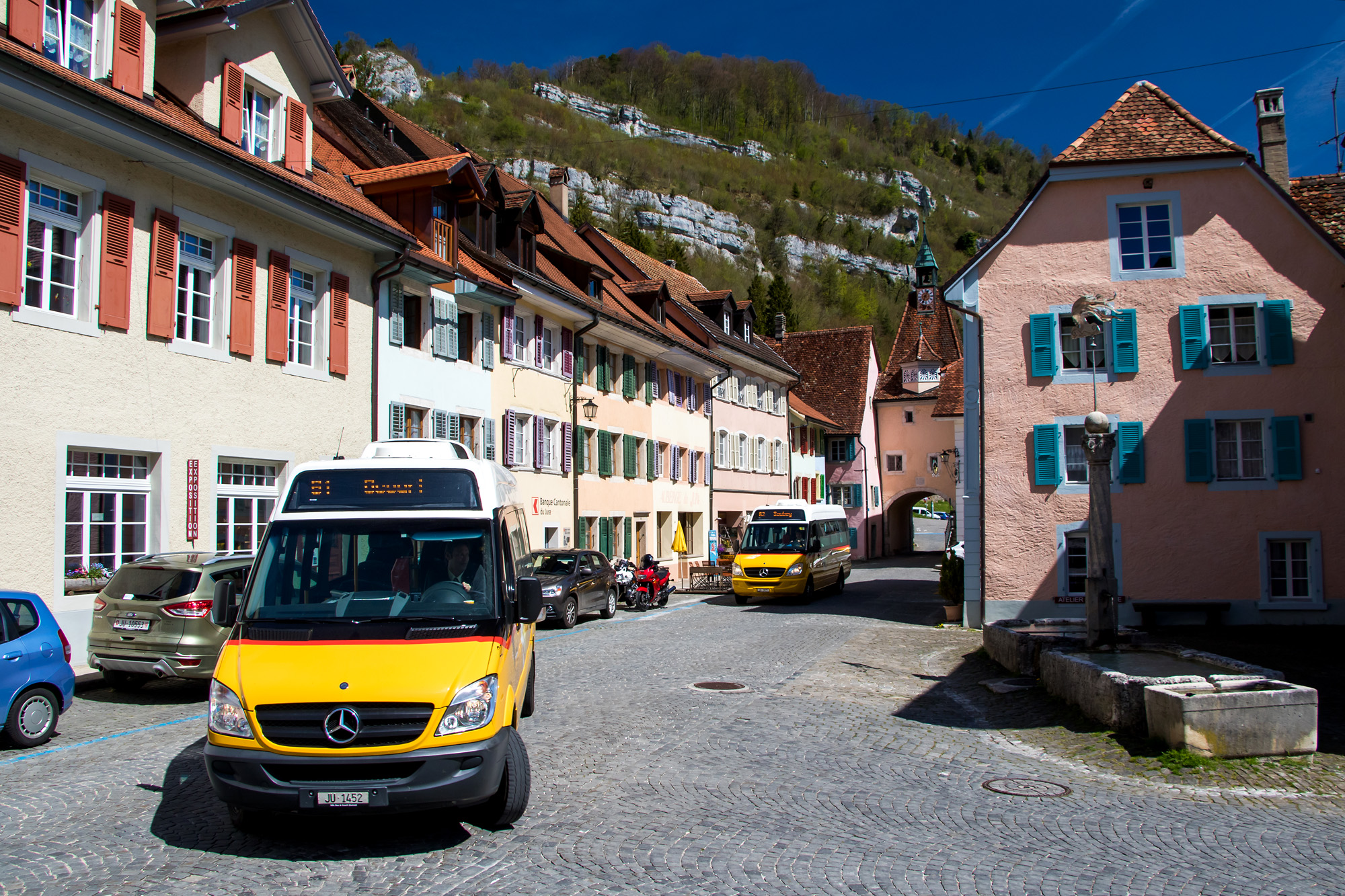 Postauto-Umzug der zwei Mittagskurse durch die Altstadt von St. Ursanne (JU)