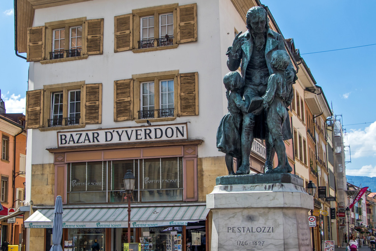 Pestalozzi-Denkmal auf dem gleichnamigen Platz. Die Stadt Yverdon kaufte seinerzeit die Burg, um dem renommierten Pädagogen dort eine Schule einzurichten. Von dort aus verbreitete sich sein Einfluss bis weit in die Nachbarländer