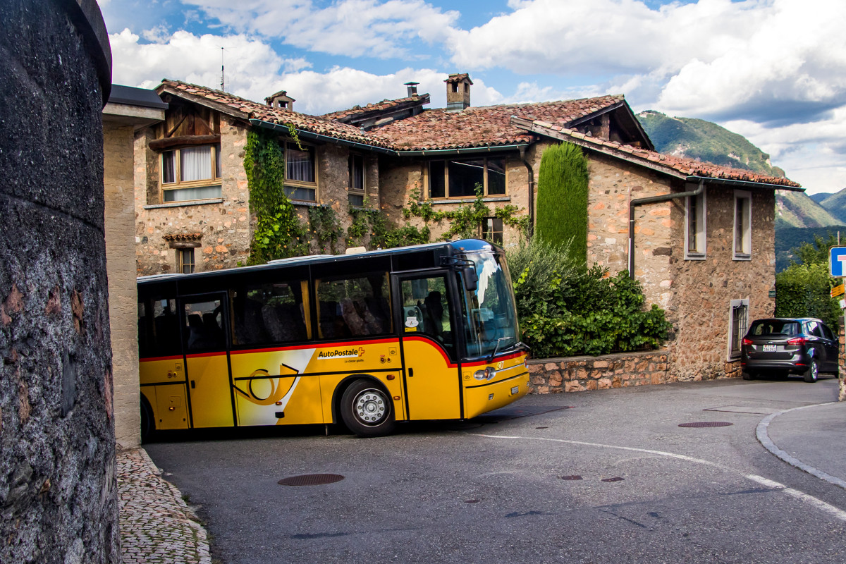 Das eigentliche Carona-Modell sehe ich leider nur auf einem Schülerkurs vorbeihuschen: Der RizziBus/Mauri Carro Alpino wurde von einem Tessiner Ingenieur speziell auf den Torbogen von Carona zugeschnitten. Er verfügt über kürzere Aussenspiegel und lässt sich hydraulisch absenken, um durch die Engstelle zu passen. 